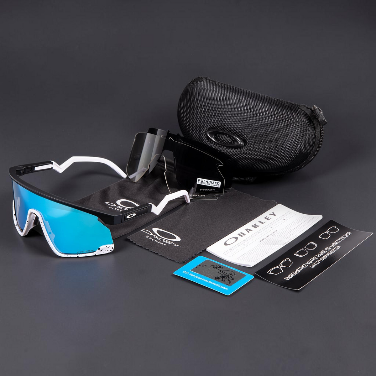 Gafas de sol OakGlasses Bxtr con montura blanca y negra, lentes azules espejadas, estuche rígido y accesorios