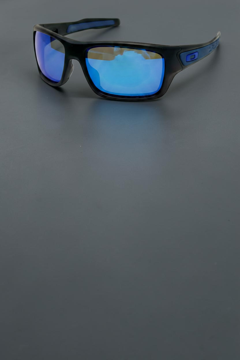 Gafas de sol deportivas OakGlasses Turbine con montura negra y lentes espejadas azules sobre fondo oscuro